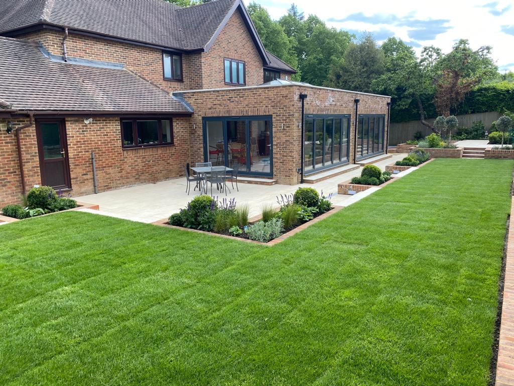 Modern family garden with outdoor dining area and raised beds designed by Tom Murphy